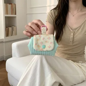 Small floral quilted coin purse for lipsticks or earphones, handheld detail view.