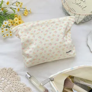 Macro view of cream corduroy makeup bag with floral print and Sozakka label