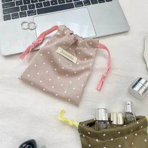 Close-up of pink and green satin polka dot drawstring pouches for jewelry storage
