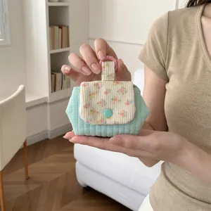 Close-up of floral quilted coin purse for lipstick and earphones storage.