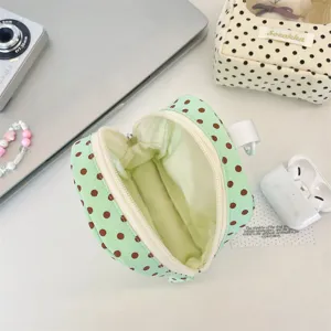 Detailed interior view of a light green polka dot mini storage pouch with zipper