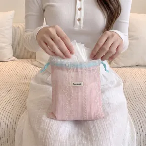 Close-up of floral embroidered drawstring pouch used for organizing sanitary pads.