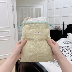 Close-up of fresh yellow drawstring storage bag with delicate floral embroidery detail