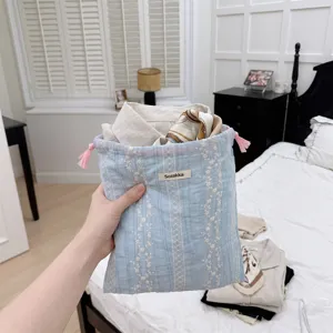 Detailed shot of a light blue floral embroidery drawstring pouch for travel organization.
