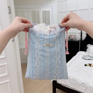 Detailed view of blue floral embroidered drawstring storage bag for travel organization
