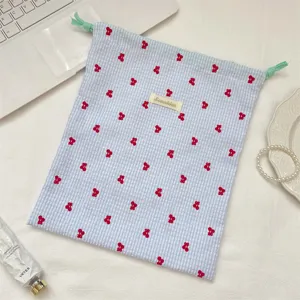 Vista detallada de la bolsa de almacenamiento de tela a cuadros con bordado de cerezas