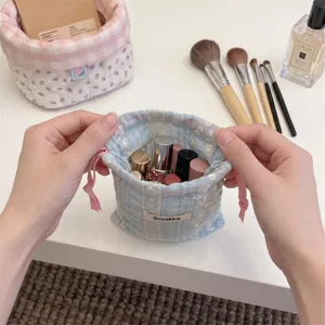 Detail of blue floral embroidered drawstring pouch showing interior cosmetic storage.