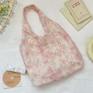 Close-up detail of pink tie-dye tote bag featuring delicate white floral branch embroidery