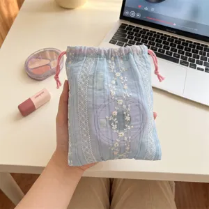 Close-up shot of a light blue vertical stripe drawstring pouch with white floral embroidery