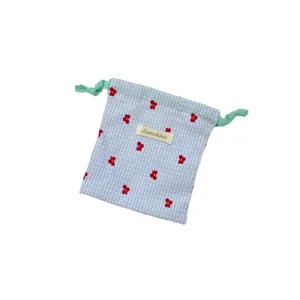 Bolsa con cordón a cuadros azules y blancos con bordado de cerezas rojas y lazos verdes