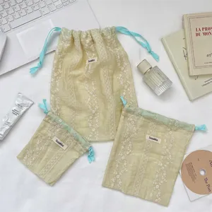 Three floral embroidery drawstring pouches in a fresh lifestyle setting