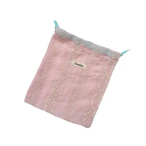 Fresh pink drawstring bag with floral embroidery and vertical stripes for travel storage