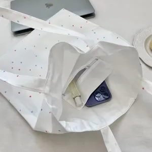 Gedetailleerd binnenaanzicht van een canvas tas met stippen en een binnenzak met rits