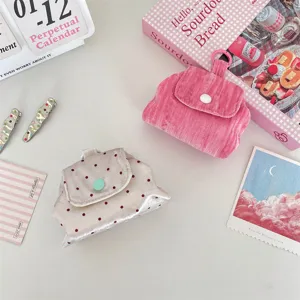 Gedetailleerd overzicht van roze corduroy en satijnen mini-tasjes voor kabelopslag
