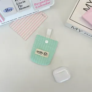 Close-up of a mint green quilted earphone pouch with a brand label and snap button