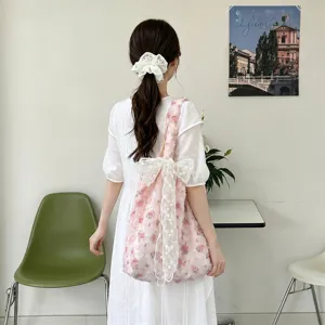 Pink rose floral tote bag with a white lace bow carried by a girl in a white dress