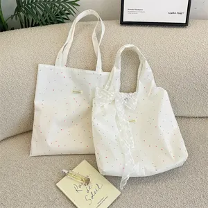 Set van crème canvas tassen met stippen en een verfijnde kanten strik.