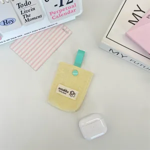 Detailed shot of yellow quilted earphone storage pouch with teal ribbon loop