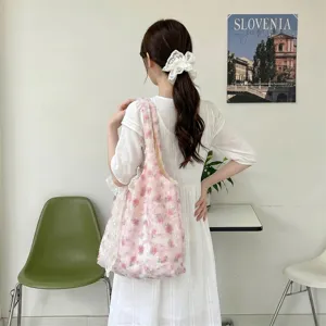 Back view of pink rose floral tote bag styled with white dress