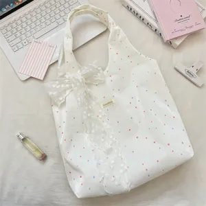 Detailweergave van witte canvas tas met stippen en een esthetische kanten strik