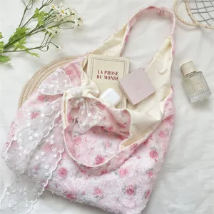 Close-up detail of the pink rose floral tote bag featuring a delicate lace bow.