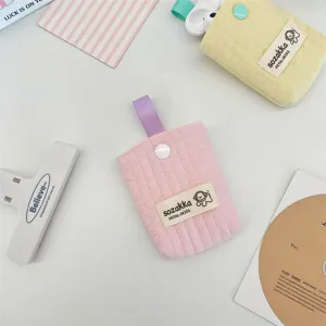 Macro view of pink and yellow quilted fabric earphone pouches featuring cute snap buttons