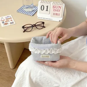 Détail d'un panier de rangement en tissu bleu avec bordure en dentelle blanche
