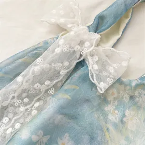 Close-up of white lace bow detail on a light blue floral tote bag