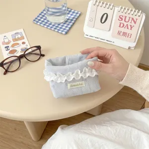 Gros plan d'un panier de rangement en tissu bleu clair avec bordure en dentelle blanche