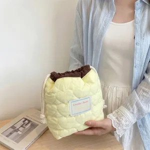 Vista detallada de una bolsa de almacenamiento acolchada con corazones amarillos y cordón