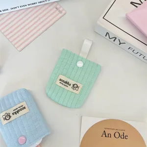 Detailed view of quilted cotton earphone storage pouch with cute dog label and button