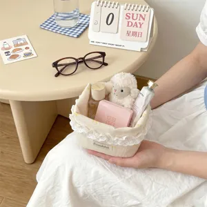 Vue détaillée d'un panier de rangement en tissu crème avec dentelle pour le bureau