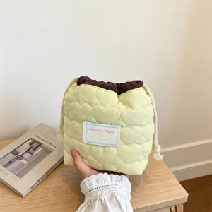 Vista detallada de la bolsa amarilla acolchada con corazones y cordón para cosméticos
