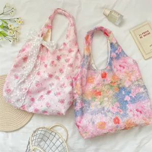 Detail view of pink rose floral pattern tote bag with delicate white lace bow accessory