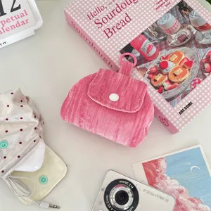 Detailweergave van het roze corduroy minitasje met drukknoop voor het opbergen van oortjes