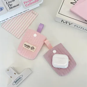 Close-up view of two quilted cotton fabric AirPods pouches with colorful ribbon loops