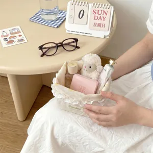 Gros plan d'un panier de rangement en tissu dentelle crème pour l'organisation du maquillage