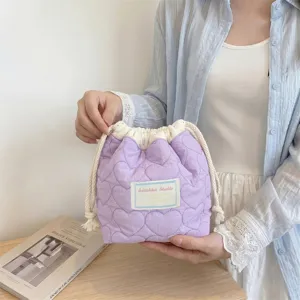 Detalle de un neceser de lavanda acolchado con corazones sostenuto por la mano