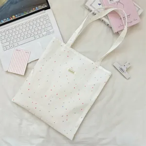 Crème canvas draagtas met roze en blauwe stippen in een stijlvolle lifestyle-setting