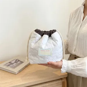 Primer plano detallado de un neceser acolchado con corazones y cordón para cosméticos