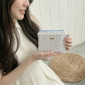 Petite pochette fleurie avec bordure en dentelle blanche pour écouteurs et pièces.