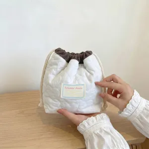 Detalle de una bolsa de cosméticos acolchada con corazones y cordón en blanco y marrón