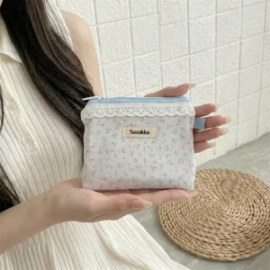 Vue détaillée d'une petite pochette à fleurs avec bordure en dentelle tenue à la main