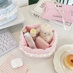 Gros plan d'un panier en tissu rose avec bordure en dentelle, rempli de cosmétiques