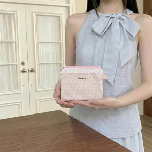 Petite pochette à fleurs avec dentelle et étiquette Sozakka tenue par un mannequin