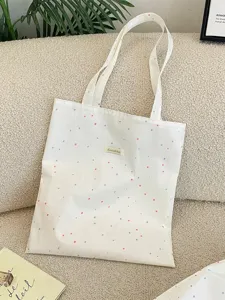 Artistieke crèmekleurige canvas draagtas met stippen op een zachte beige sofa