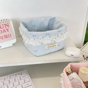 Vue détaillée d'un panier de rangement en tissu bleu clair avec motifs de cœurs et dentelle