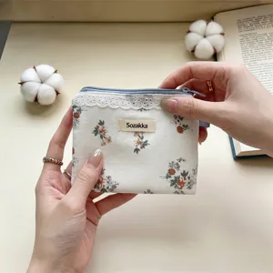 Gros plan sur la petite pochette florale avec bordure en dentelle et étiquette Sozakka.