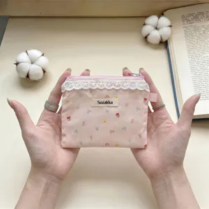 Vue détaillée de la pochette florale rose avec de la dentelle blanche et le logo Sozakka