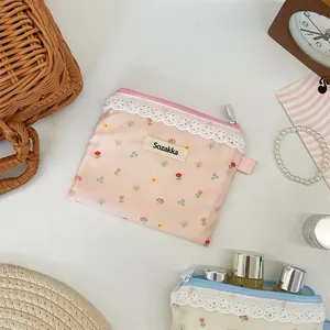 Gros plan sur le motif floral et la bordure en dentelle délicate de la petite pochette